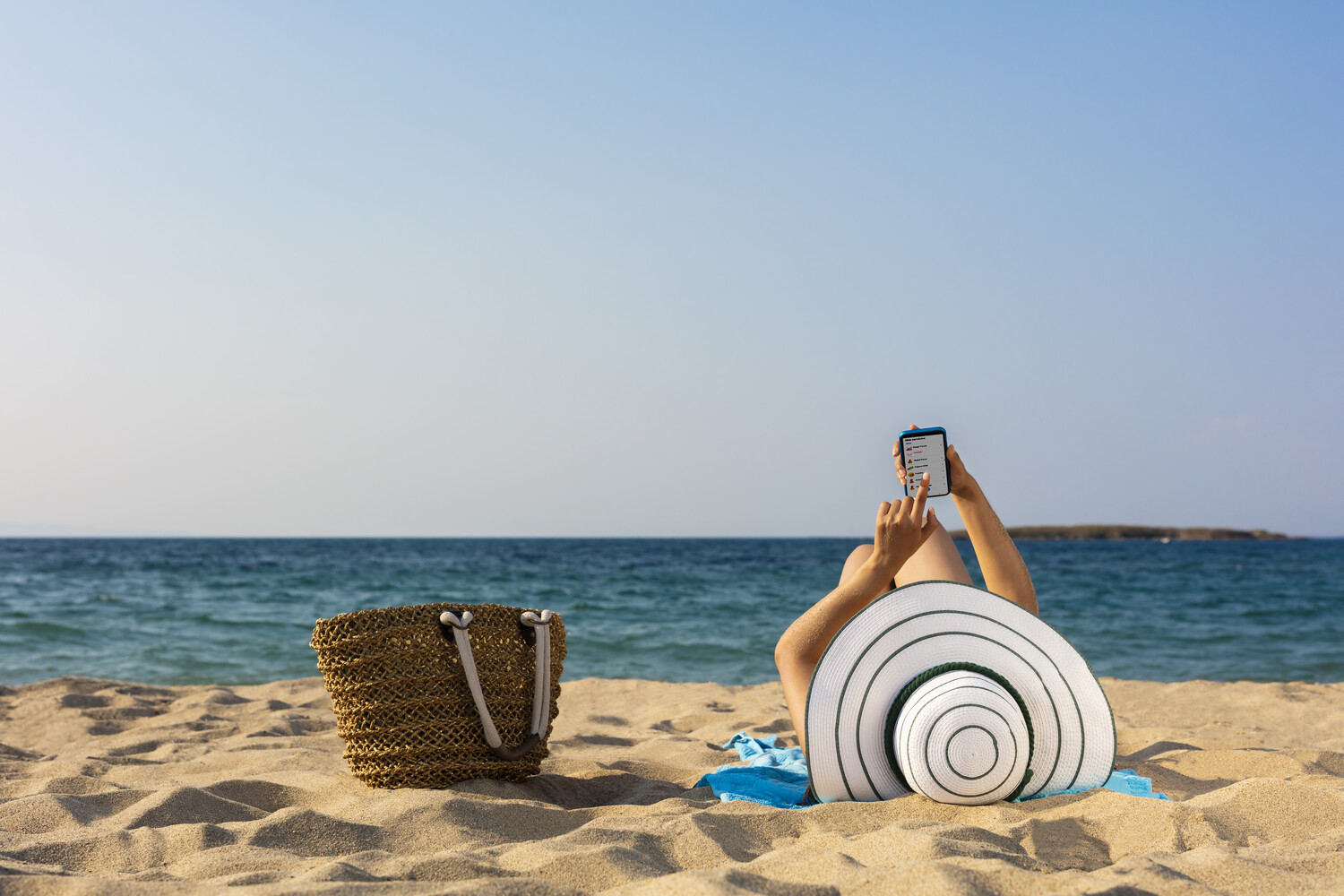 woman with smartphone on beach